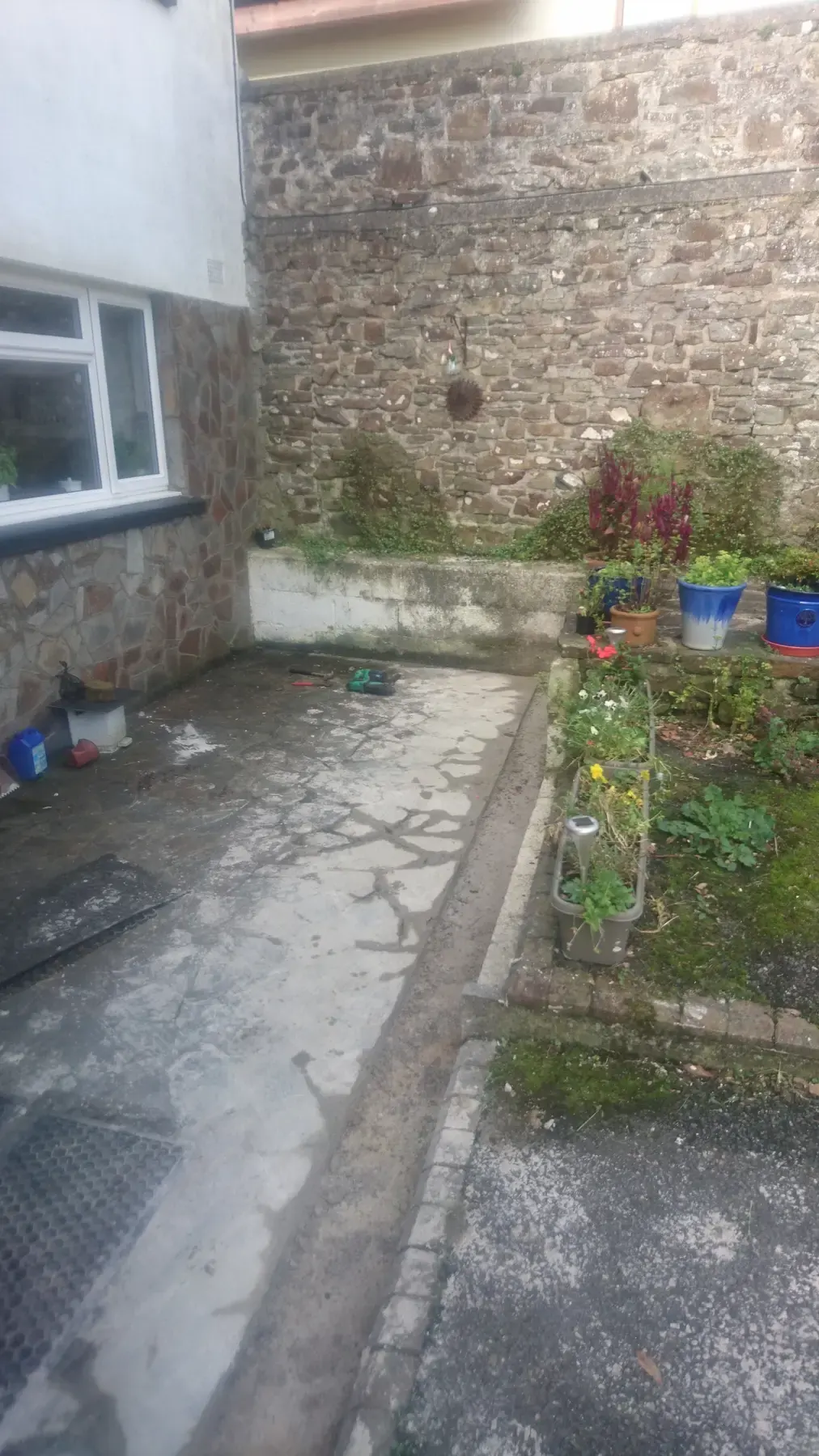 Worn garden courtyard before improvement work