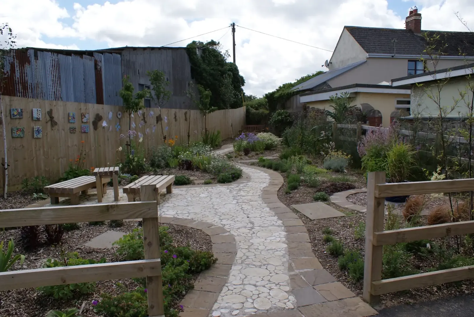 Curved garden path flowing through established planting
